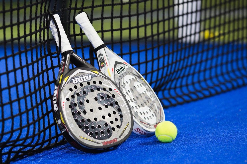 Twee padel spelers demonstreren hoe je beter padel speelt met goede positie en samenwerking op de baan